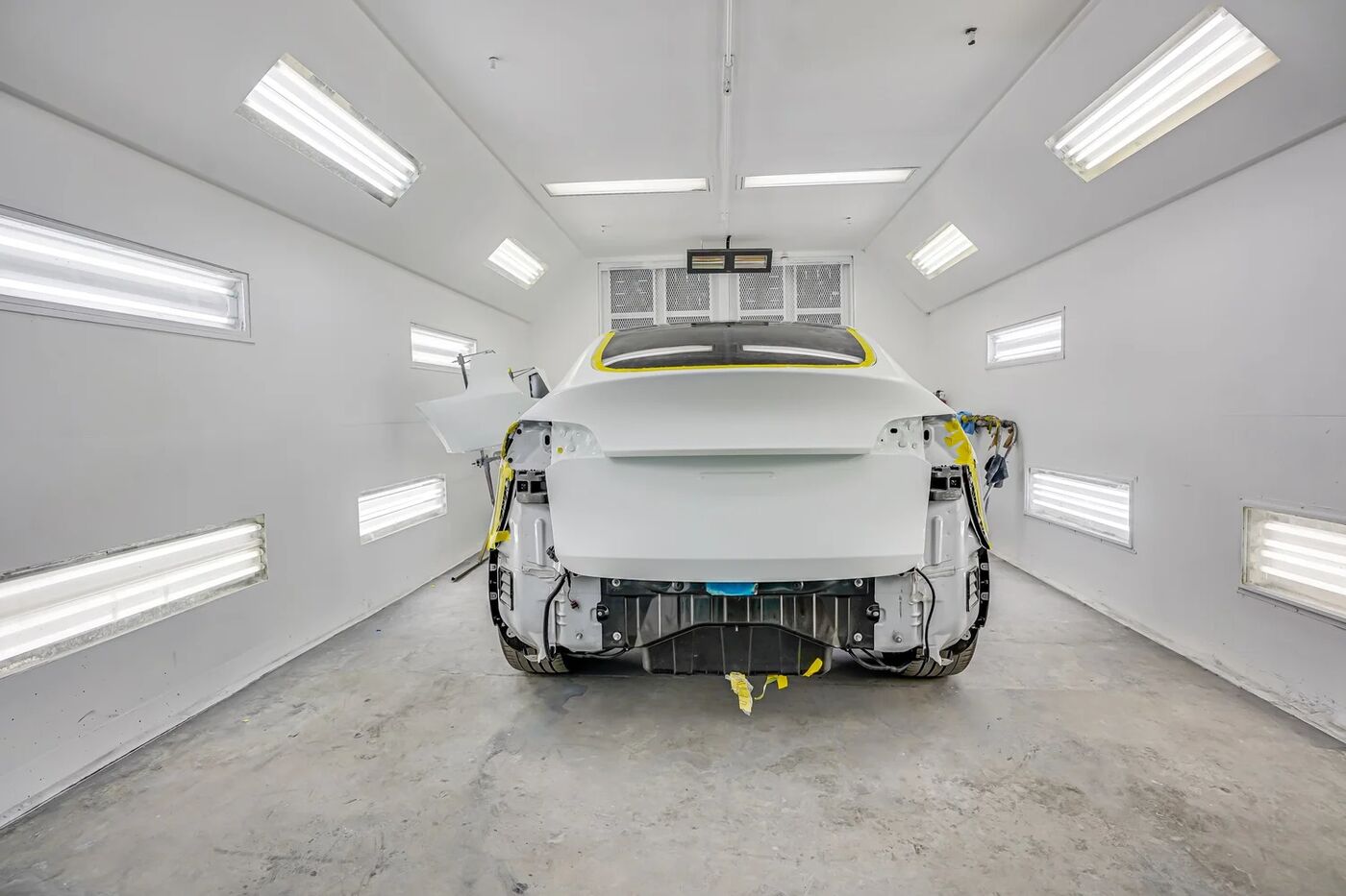 Tesla Model Y in the paint booth mid repair